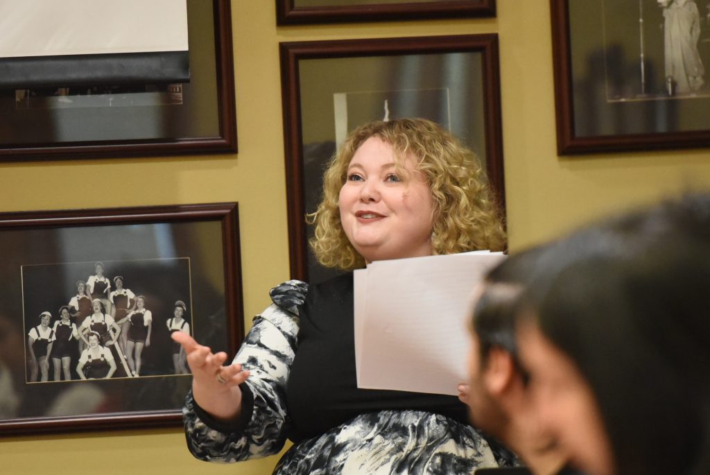 Megan Murph, Ph.D. holding papers in her hand while presenting her research.