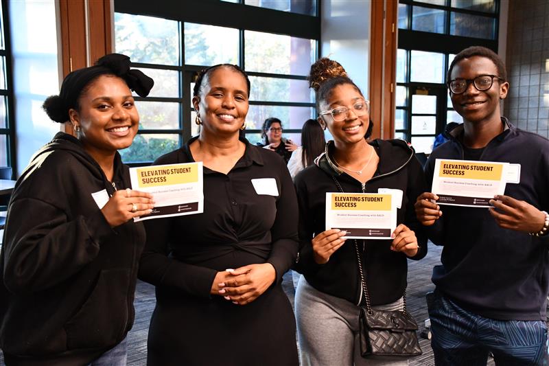 Velma Buckner standing with three students after a student success coaching event.