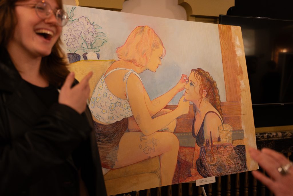 Student displaying art at Chancellors Arts Showcase