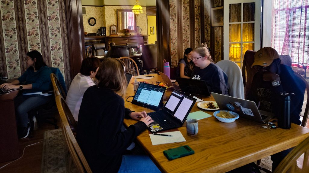 Student writing at the Conley House