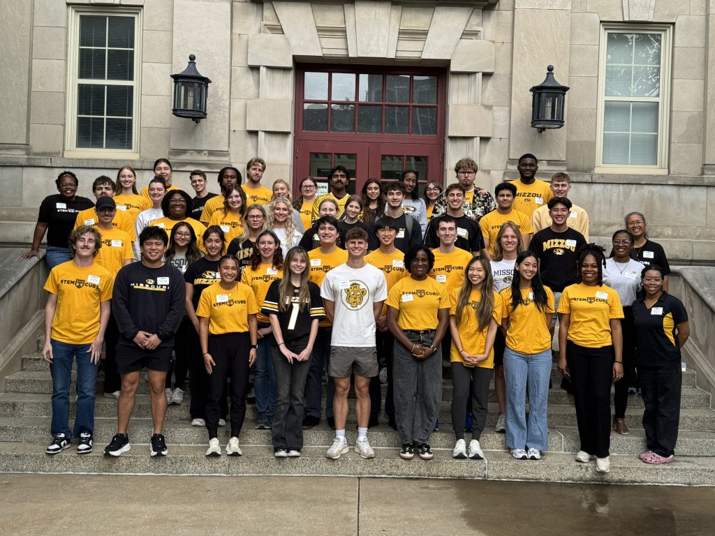 Group of volunteers, instructors, and staff on stairs in front of Townsend Hall between STEM Cubs sessions