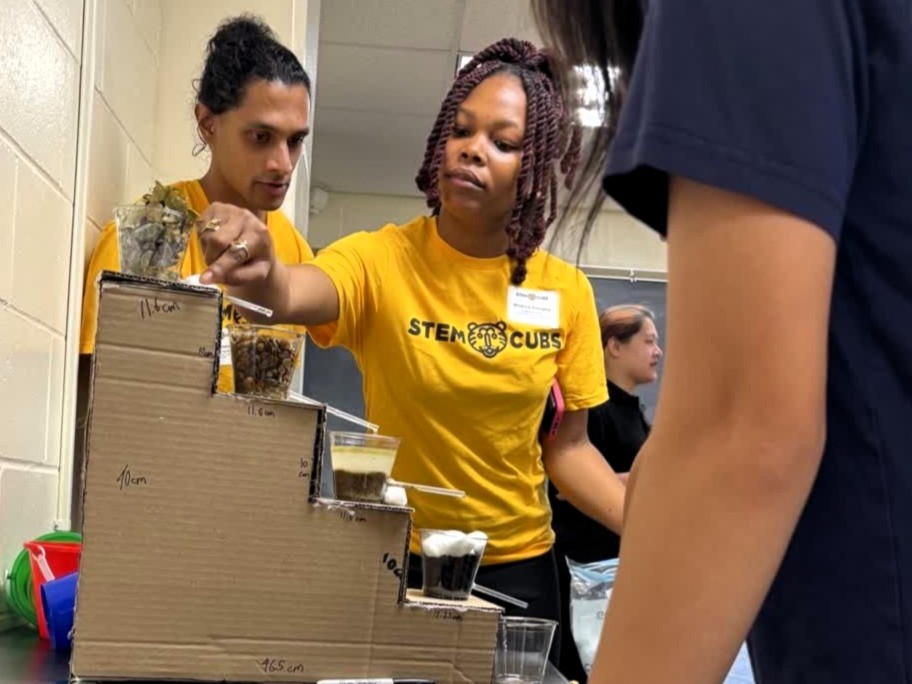 Chemistry doctoral student Mildred Emegha shows the water purification model
