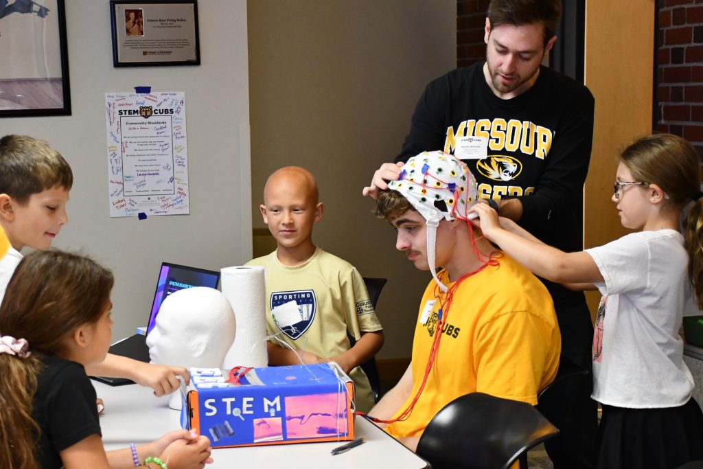 Neuroscience doctoral student Rylan Batten demonstrates preparation for an EEG