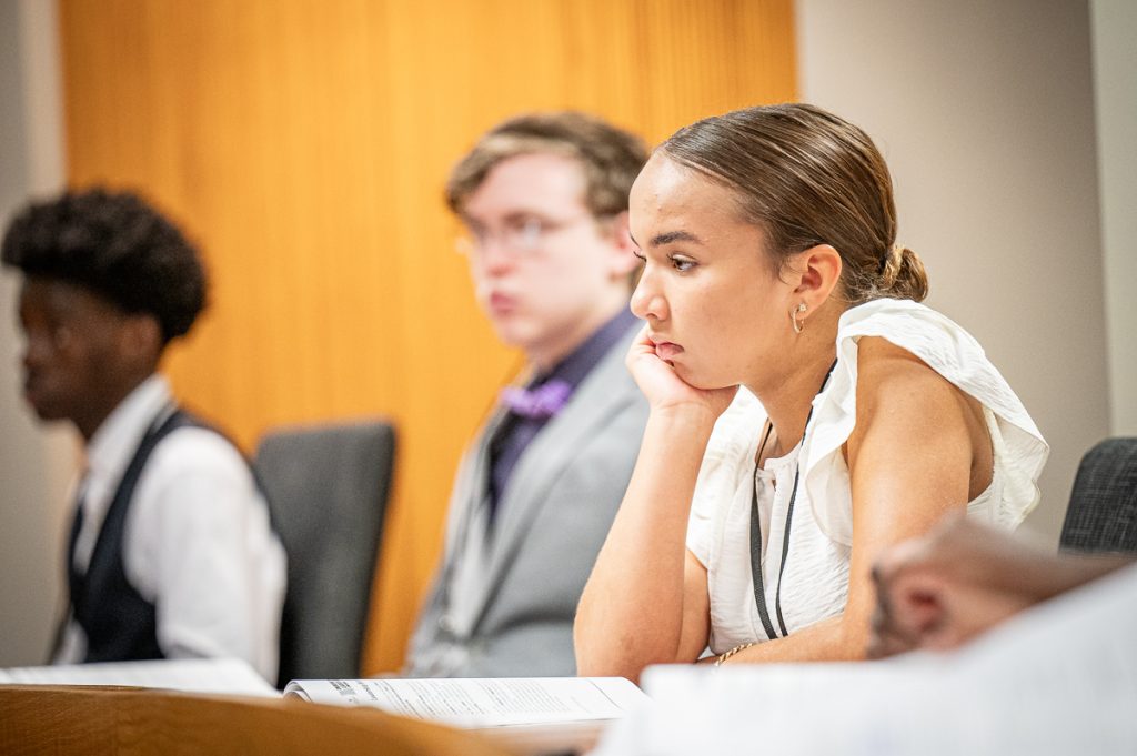 three students sitting during a presentation