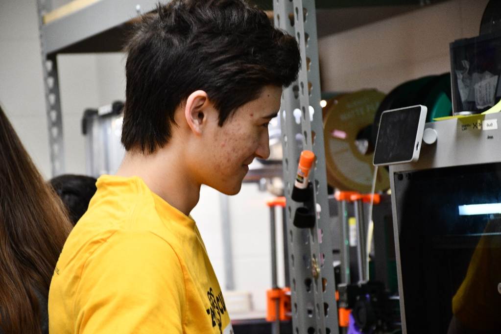 Male college students looks at 3D printer screen
