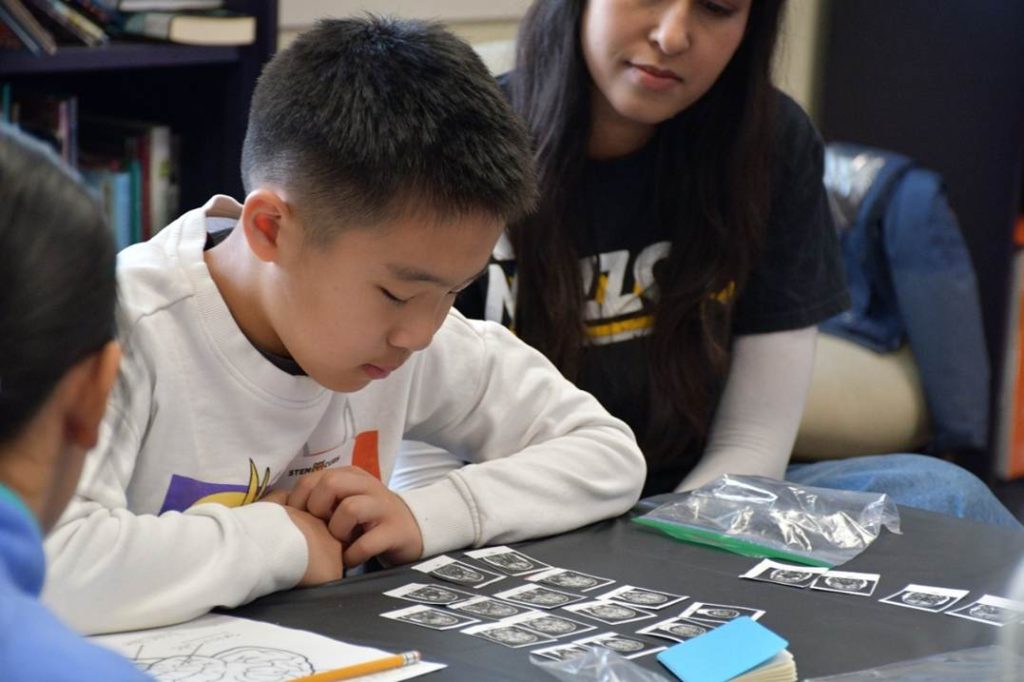 Young boy looks at small images of brain scans