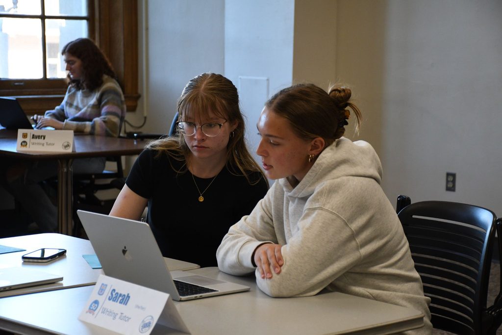 Students work on writing assignments during the Dine & Draft. 
