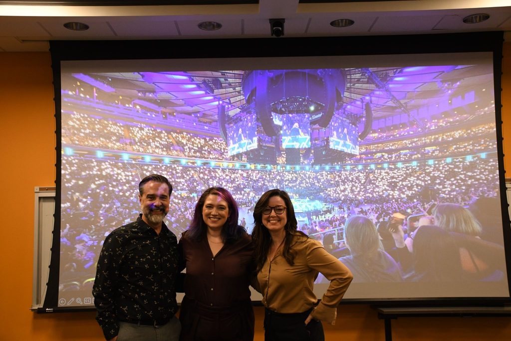 Aaron Harms Emily Friedman and Bailey Boyd in front of the game Dimension 20 being played at Madison Square Garden. 